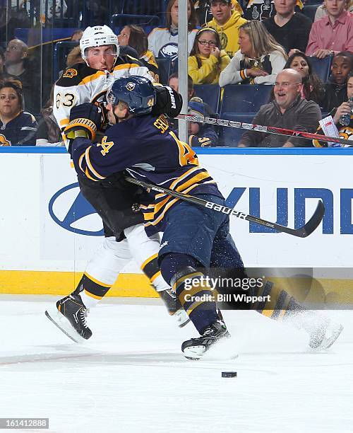 Andrej Sekera of the Buffalo Sabres checks Brad Marchand of the Boston Bruins on February 10, 2013 at the First Niagara Center in Buffalo, New York.