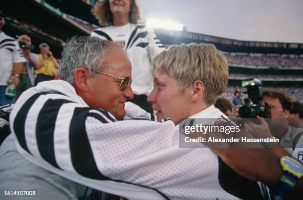 German coach Dieter Kolark with German athlete Astrid Kumbernuss after Kumbernuss had won gold in the women's shot put event of the 1996 Summer...