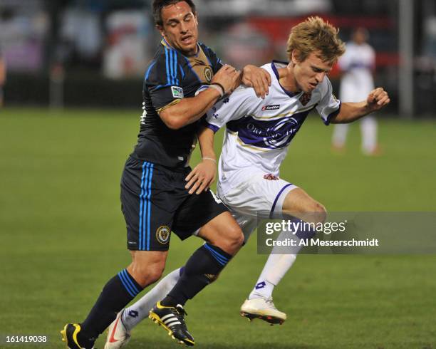 Midfielder Danny Cruz of the Philadelphia Union runs with Brian Fekete of Orlando City February 9, 2013 in the first round of the Disney Pro Soccer...