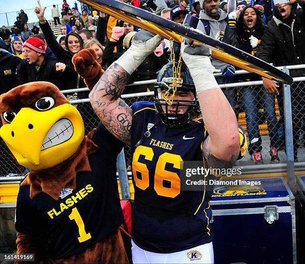 Offensive linemen Brian Winters of the Kent State Golden Flashes celebrates with the Wagon Wheel trophy after a game with the Akron Zips at Dix...