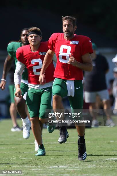 New York Jets quarterback Zach Wilson and New York Jets quarterback Aaron Rodgers warm up before practice during the NFL Carolina Panthers training...