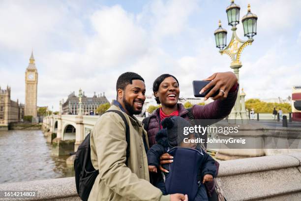 young black couple with baby taking selfie on day out in london - family travel stock pictures, royalty-free photos & images