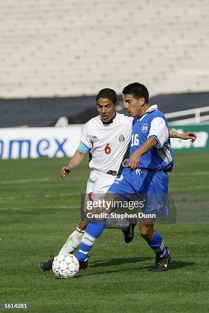 Adonay Martinez of El Salvador kicks the ball away from Luis Sosa of Mexico in their first round CONCACAF Gold Cup match at the Rose Bowl in...