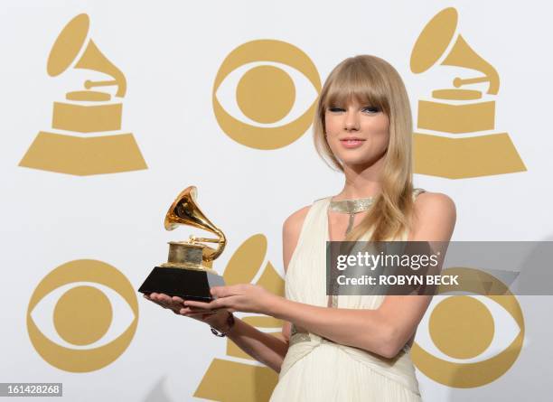 Singer Taylor Swift poses with her trophy for best song written for visual media for "Safe and Sound" in the press room at the Staples Center during...