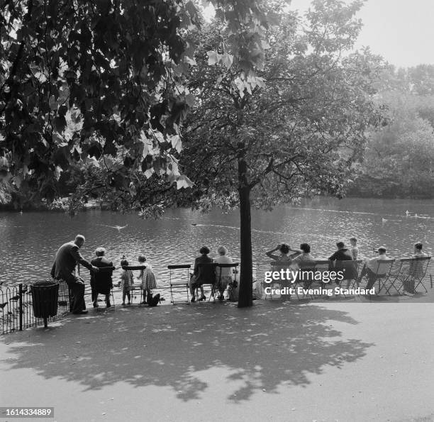 Tourists seated on chairs opposite the lake in St James's Park, September 1st, 1959.