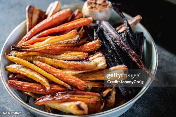 portrait of roasted root vegetables and garlic - serving dish stock pictures, royalty-free photos & images