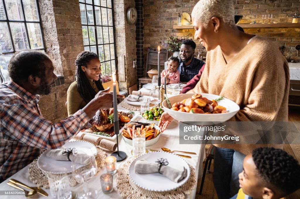 Hostess placing bowls of prepared food on festive table