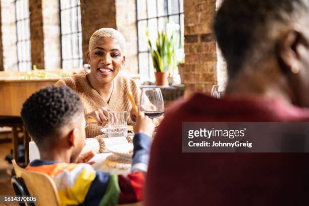 mother and son exchanging smiles during holiday lunch - annual event stock pictures, royalty-free photos & images
