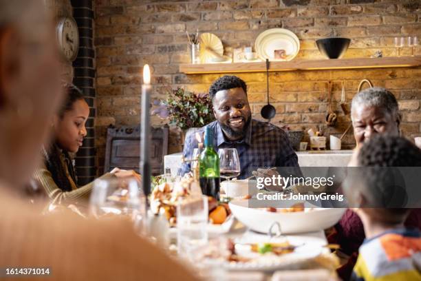 cheerful black family enjoying festive meal - annual event stock pictures, royalty-free photos & images