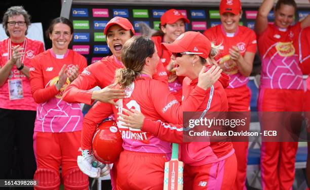 Tammy Beaumont of Welsh Fire Women embraces team mates Sophia Dunkley and Alex Hartley after being dismissed for 118 during The Hundred match between...