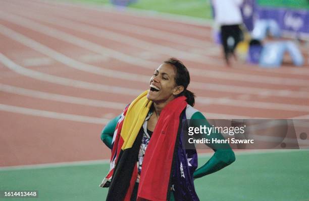 Australian athlete Cathy Freeman, the Australian flag and the Australian Aboriginal flag draped around her shoulders, after winning the women's 400...