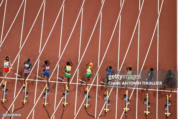 Athletes leave the starting blocks competing in the women's 100m final during the World Athletics Championships at the National Athletics Centre in...