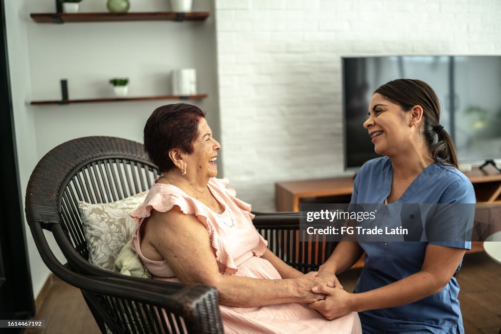Home caregiver talking with a senior woman in a nursing home