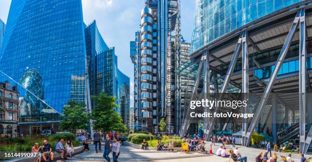 london office workers relaxing beneath futuristic city skyscrapers above - lloyds of london stockfoto's en -beelden