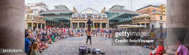 menschenmassen in london covent garden beobachten straßenkünstler bei der aufführung von panorama - darstellender künstler stock-fotos und bilder