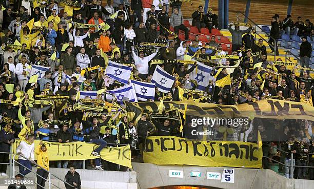 Beitar Jerusalem's supporters chant slogans beside a banner during an Israeli championship football match between Beitar Jerusalem and Bnei Sakhnin...