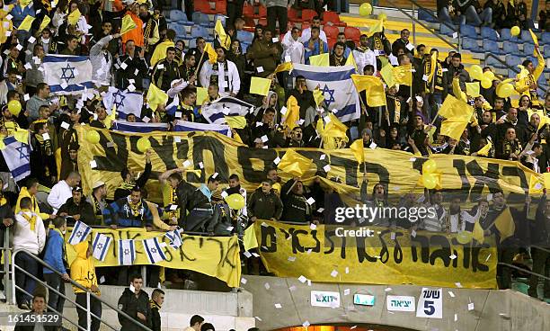 Beitar Jerusalem's supporters chant slogans beside a banner during an Israeli championship football match between Beitar Jerusalem and Bnei Sakhnin...