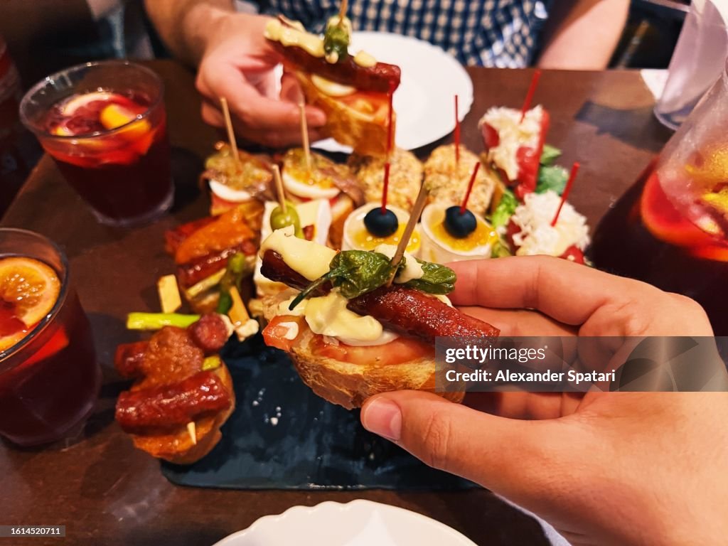 Eating pincho tapas at the restaurant, personal perspective view, Barcelona, Spain