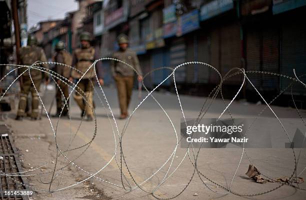 Indian government forces patrol deserted streets during a curfew on the third consecutive day after India hanged Indian parliament convict Afzal Guru...