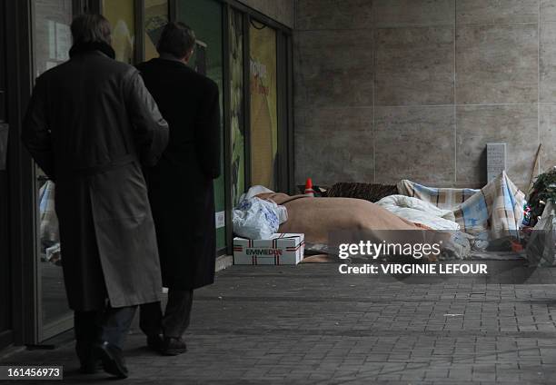 Photo taken on February 11, 2013 shows homeless people near the entrance to a subway station in Brussels as temperatures have dropped recently in...