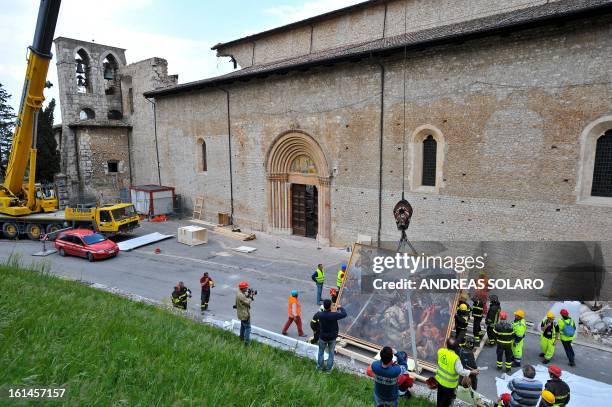 Italian fire-fighters carry 'The Battle of Celestine V' painting rescued from the damaged Santa Maria di Collemaggio's Basilica, in L'Aquila, on...