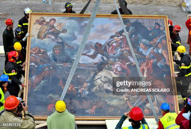 Italian fire-fighters carry 'The Battle of Celestine V' painting rescued from the damaged Santa Maria di Collemaggio's Basilica, in L'Aquila, on...