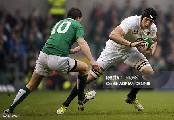 England's No 8 Tom Wood runs with the ball in front of Ireland's fly half Jonathan Sexton during the Six Nations international rugby union match...