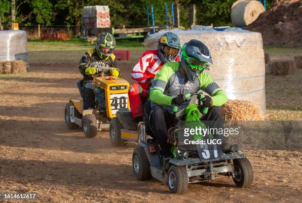 Three racing lawn mower drivers jostle for position in the BLMRA 500, a Le Mans style 500 mile overnight lawn mower race in a field in West Sussex,...