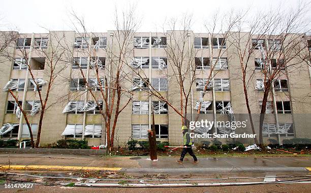 An electrical crewman walks in front of a building with blown out windows on Hardy Street across from the University of Southern Mississippi after a...