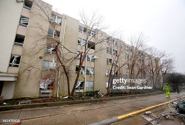 An electrical crewman walks in front of a building with blown out windows on Hardy Street across from the University of Southern Mississippi after a...