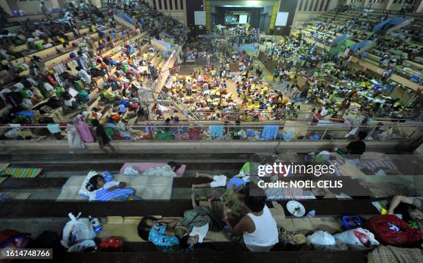 Residents affected by the devastating flash flood sleep on a gymnasium in Iligan City on December 24, 2011. Thousands of people in the southern...