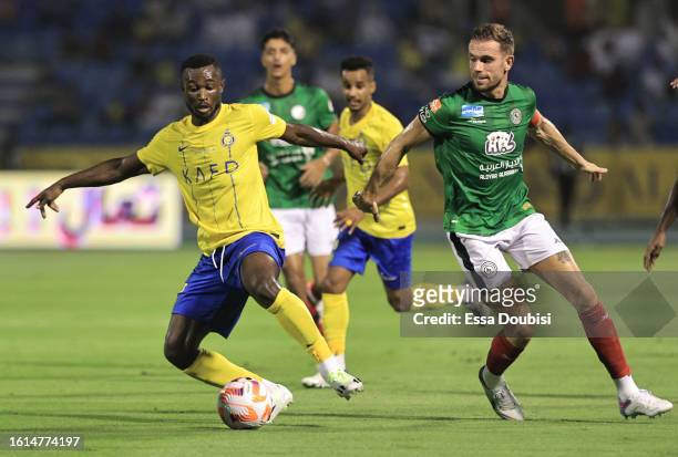Jordan Henderson of Al-Ettifaq and Ghislain Konan of Al Nassr battle for possession during the Saudi Pro League match between Al-Ettifaq and Al Nassr...