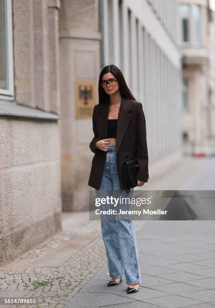 Leo Eberlin seen wearing District Vision black sunglasses with orange transparent lenses, Leo Mathild diamond jewelry, Dior black bra top, Khaite...