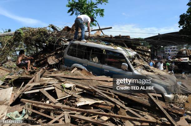 Residents work among the debris and flood waters in Cagayan de Oro, in southern island of Mindnanao on December 18 a day after Typhoon Washi wrought...