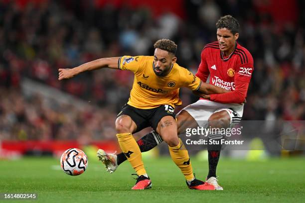 Matheus Cunha of Wolverhampton Wanderers is challenged by Raphael Varane of Manchester Unitedduring the Premier League match between Manchester...