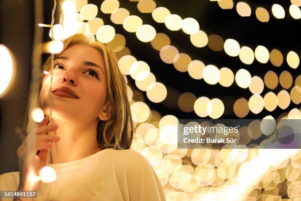 weiße menschen, porträt einer jungen frau mit bokeh-effekt unter lichtern - it happened one night stock-fotos und bilder