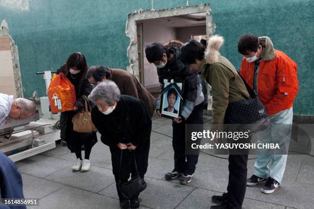 Japan-disaster-tsunami-crematorium FOCUS by John Saeki In a picture taken on March 25, 2011 relatives of deceased brothers 16-year-old Itaru and...
