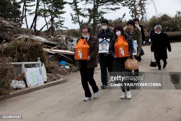Japan-disaster-tsunami-crematorium FOCUS by John Saeki In a picture taken on March 25, 2011 the family of deceased brothers 16-year-old Itaru and...