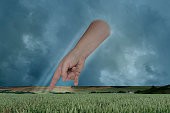 female hand points with index finger, dramatic thunderstorm sky with dark clouds, concept God's punishment, retribution for sins, global warming problem, natural disasters, hurricane, typhoon, storm