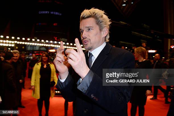 Actor and screenwriter Ethan Hawke poses for photographers as he arrives on the red carpet for the premiere of the film "Before Midnight" presented...