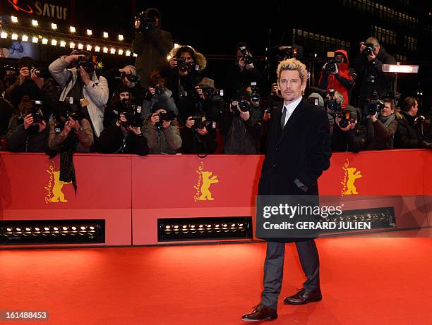 Actor and screenwriter Ethan Hawke poses for photographers as he arrives on the red carpet for the premiere of the film "Before Midnight" presented...