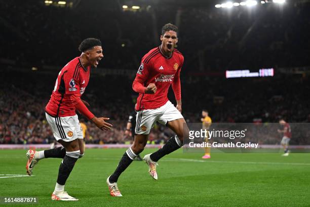 Raphael Varane of Manchester United celebrates with Jadon Sancho after scoring the team's first goal during the Premier League match between...