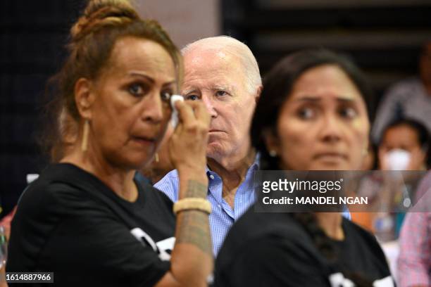 President Joe Biden listens to a speaker as a woman wipes tears from her face during a community engagement event at the Lahaina Civic Center in...