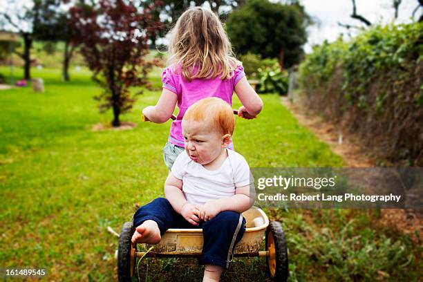 unhappy brother and happy sister, bike riding toge - barefoot redhead ストックフォトと画像