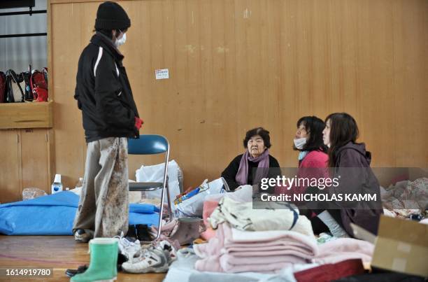 People rest in a gymnasium used as a shelter for displaced persons in the tsunami-devastated town of Otsuchi on March 18, 2011. Japan battled a...