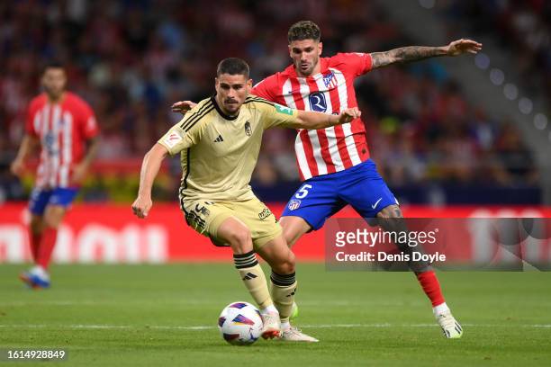 Sergio Ruiz of Granada controls the ball whilst under pressure from Rodrigo De Paul of Atletico Madrid during the LaLiga EA Sports match between...