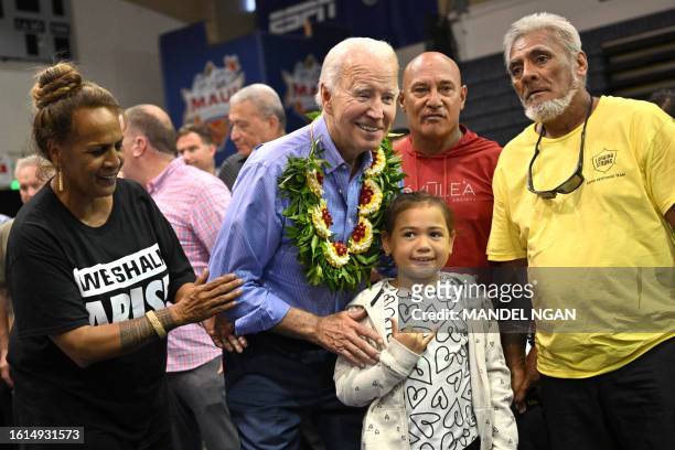President Joe Biden poses for photos after speaking during a community engagement event at the Lahaina Civic Center in Lahaina, Hawaii on August 21,...