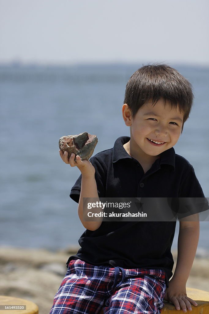 Boy with rock on his hand