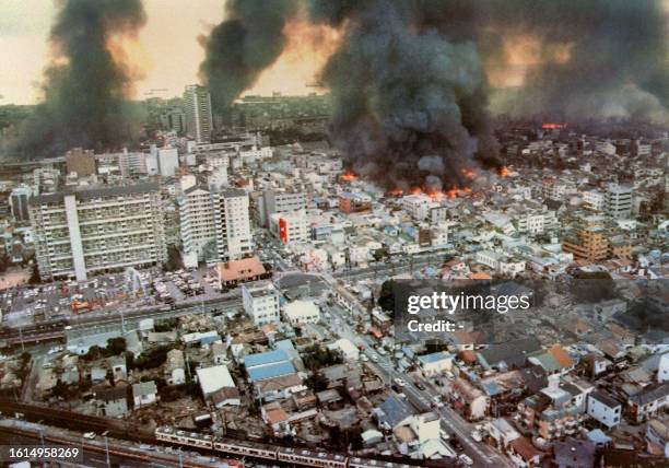 Smoke rises from the rubble after all night fires burned in Kobe, 18 January 1995, following the powerful earthquake in western Japan, 17 January...