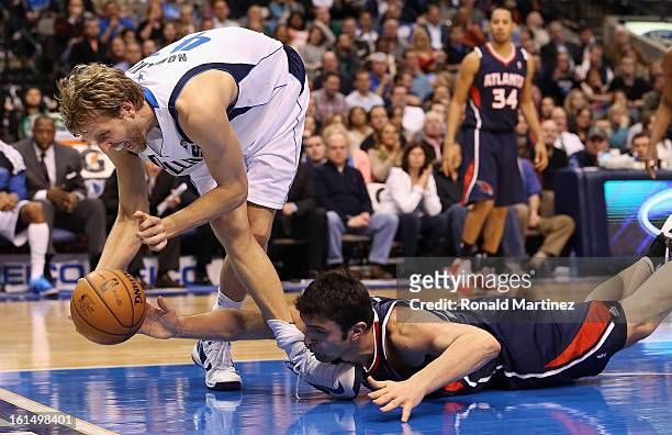 Dirk Nowitzki of the Dallas Mavericks tries to grab a loose ball against Zaza Pachulia of the Atlanta Hawks at American Airlines Center on February...